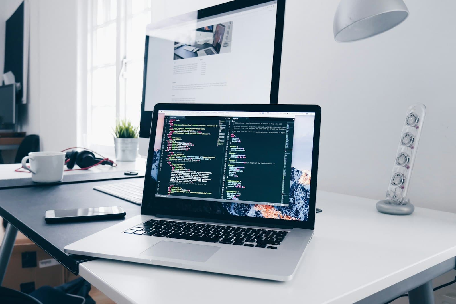 Developer working on code at a desk with a laptop